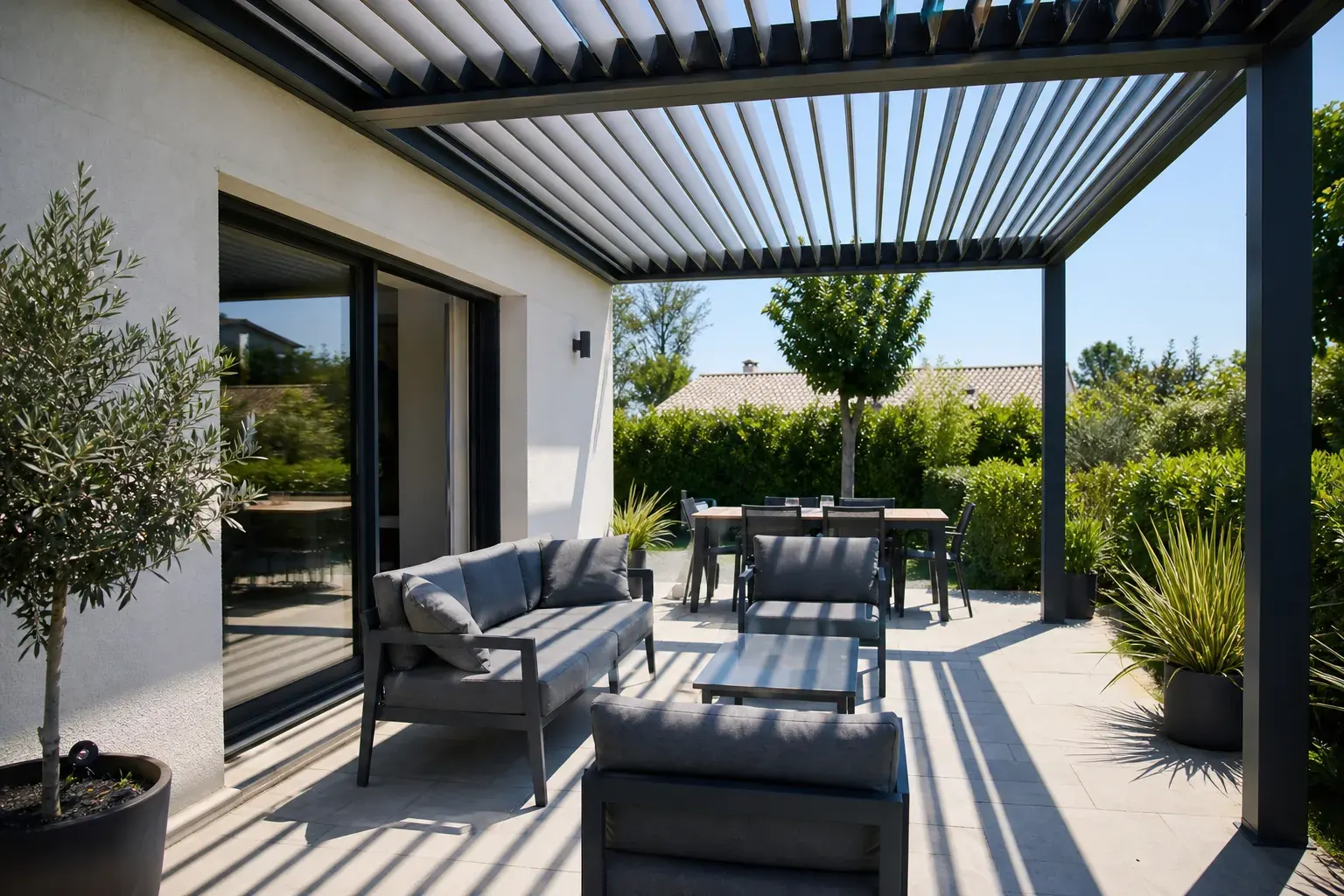 La même terrasse équipée d’une pergola bioclimatique aluminium aux lames mi-ouvertes