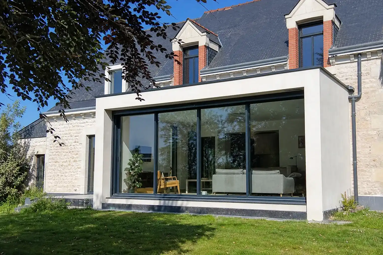 Façade avec grande baie vitrée nue exposée en plein soleil, aucune protection solaire