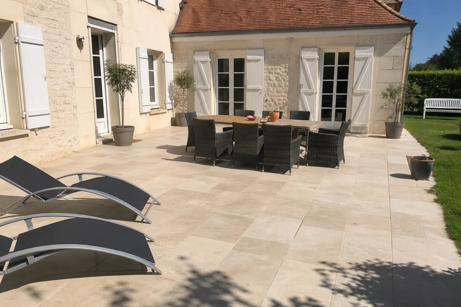 Terrasse dallée nue sans aucune protection solaire, mobilier de jardin exposé en plein soleil