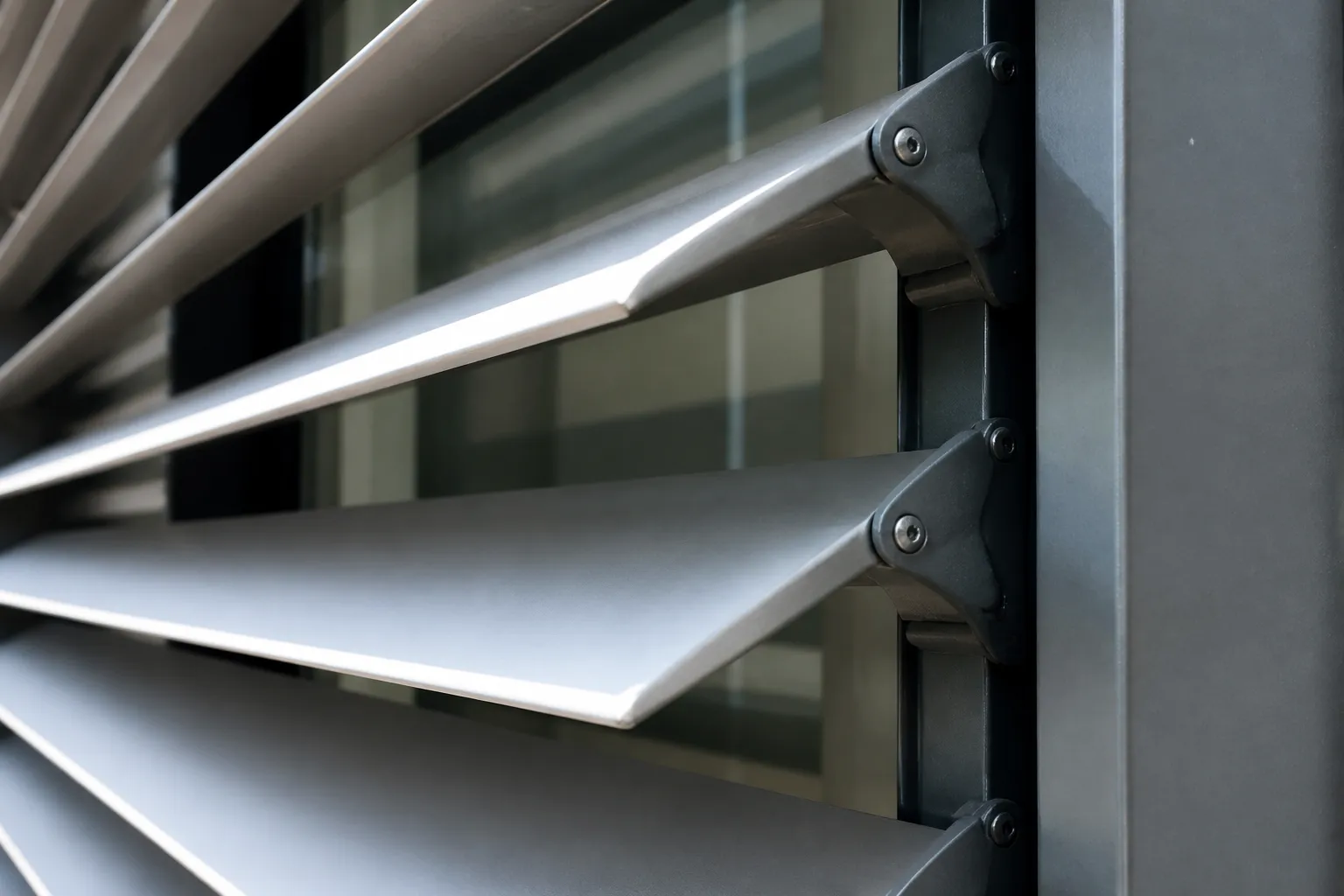 Détail de lames orientables en aluminium d’un brise-soleil fixé en façade, vue rapprochée