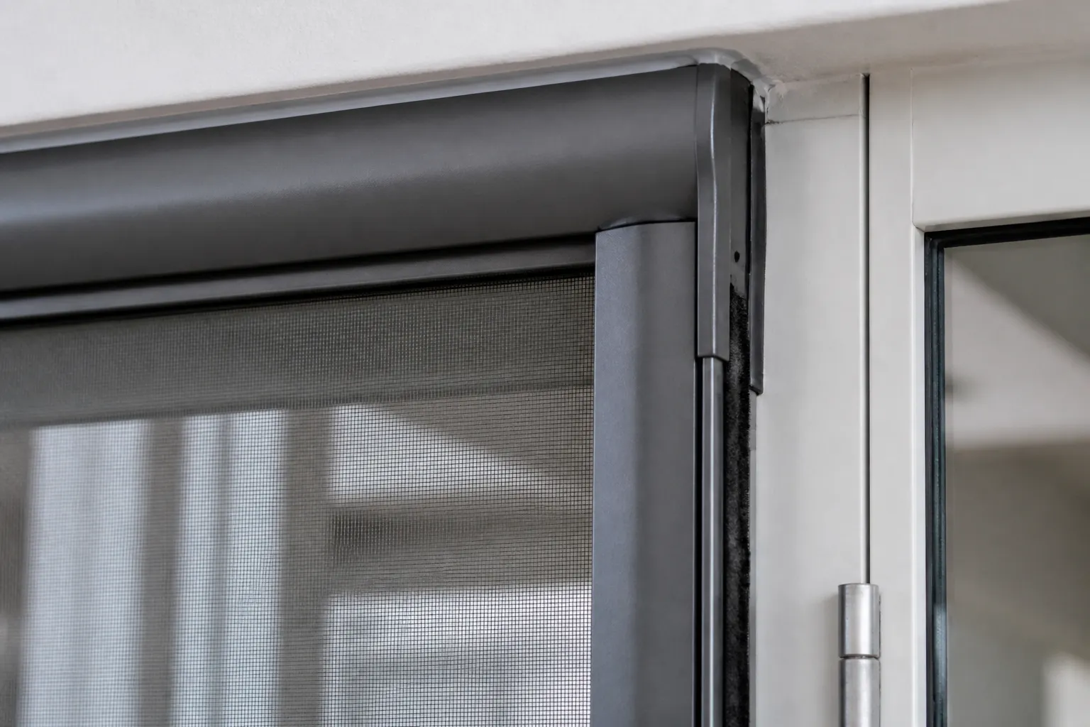 Détail d’un cadre de moustiquaire enroulable aluminium sur une porte-fenêtre