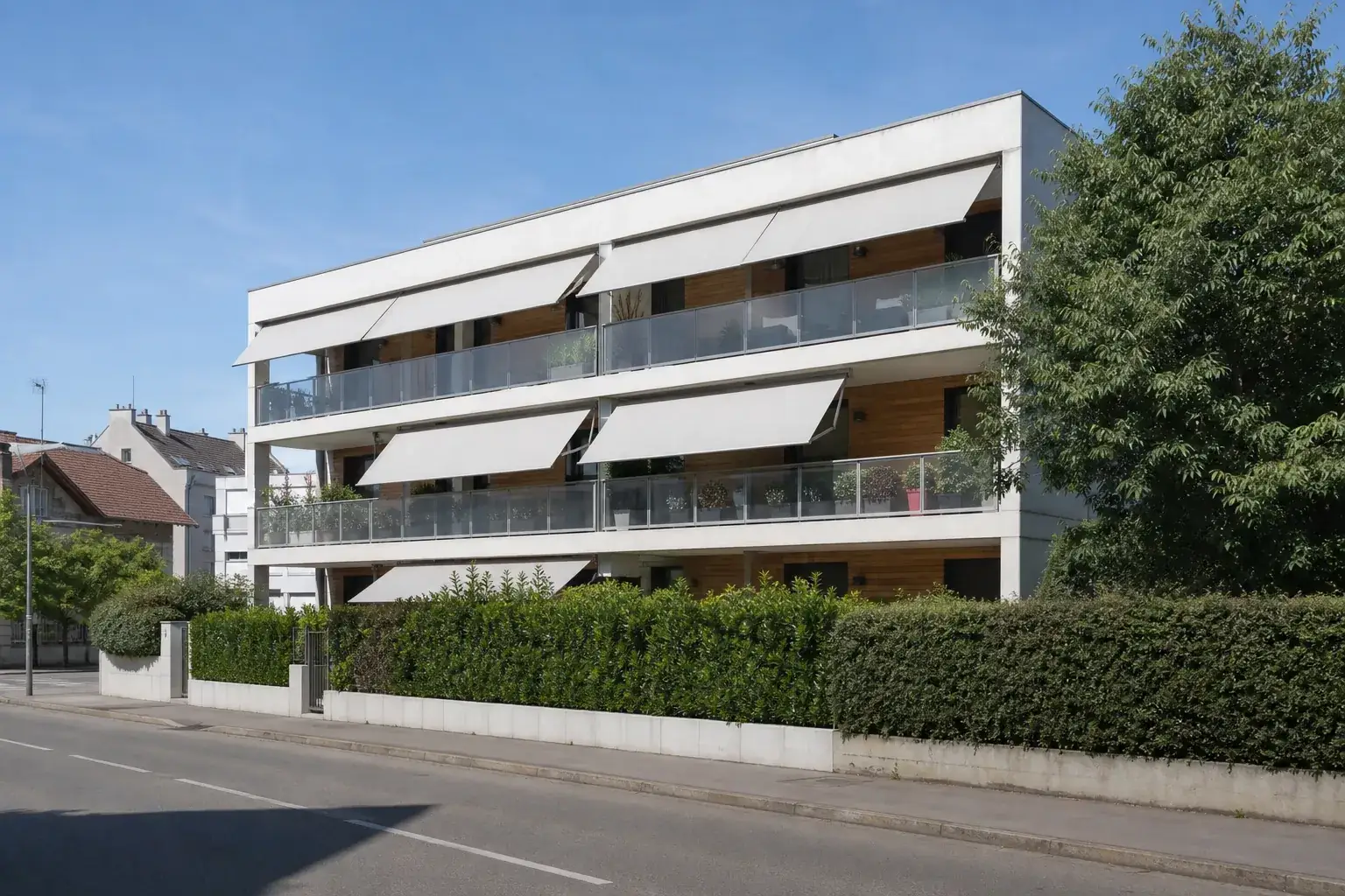 Immeuble résidentiel contemporain avec balcons équipés de stores extérieurs déployés