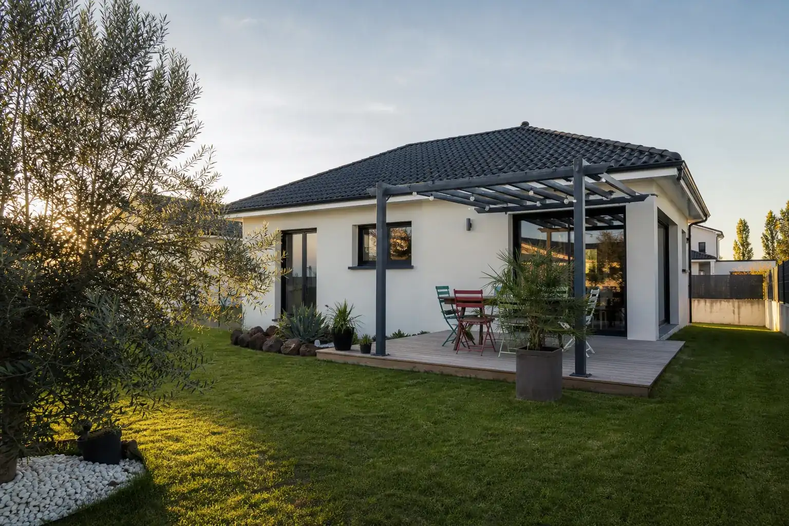 Pavillon contemporain de lotissement avec terrasse en bois équipée d’une pergola légère